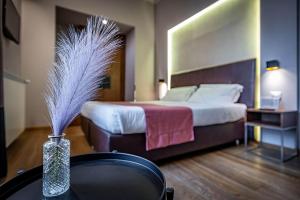 una camera d'albergo con letto e vaso con piume di Antico Centro Suite a Firenze