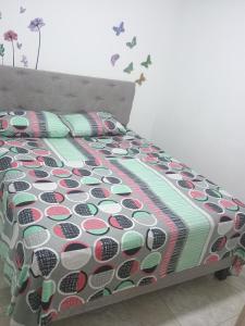 ein Bett mit einer Bettdecke und Kissen im Schlafzimmer in der Unterkunft Alojamiento valerie in Neiva