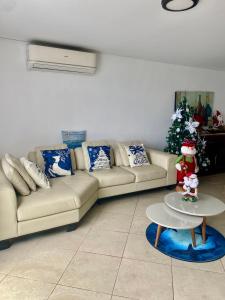 a living room with a couch and a christmas tree at Departamento Frente al Mar -MANTA in Manta