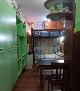 a dining room with a table and a bunk bed at Paseo Verde Condominium in Manila