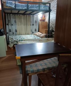 a room with two beds and a table in it at Paseo Verde Condominium in Manila