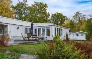 Casa blanca con patio con mesa y sillas en Beautiful Home In Sparreholm With Lake View, en Sparreholm