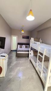 ヴロラにあるSerene Stayの二段ベッド2台、テレビが備わる客室です。