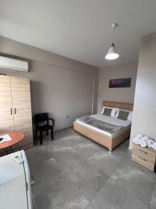a bedroom with a bed and a chair in it at Serene Stay in Vlorë