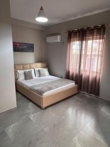 a bed in a room with a large window at Serene Stay in Vlorë