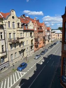 uma rua da cidade com edifícios e carros estacionados na rua em 34_Boho - DeerRest Apart em Jelenia Góra