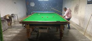 a man playing pool in a room with a pool table at Hotel Royal Plaza B&B in New Delhi