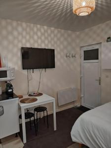 een slaapkamer met een bureau, een computer en een bed bij Studio Indépendant avec terrasse proche Paris in Épinay-sur-Seine
