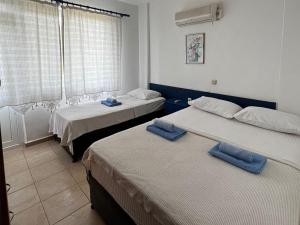 Habitación con 2 camas y toallas azules. en Mesken otel, en Gokceada Town