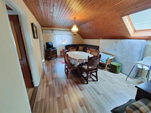 a dining room with a table and chairs in a room at Attila apartman Harkány in Harkány