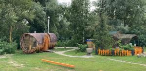 a garden with a large wooden barrel in the grass at Husky House in Kladkovka