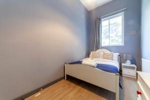 a small bedroom with a bed and a window at Couple's getaway 1BDR apt near Holland Park in London