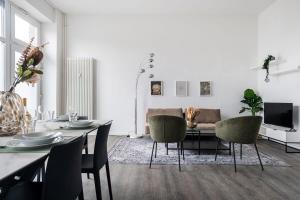 een woonkamer met een tafel en stoelen en een bank bij City Apartment: Homeoffice und Erholung vereint! in Berlijn