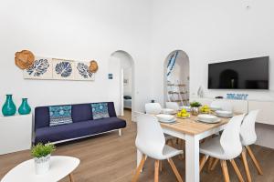 een woonkamer met een tafel en witte stoelen bij Villa Bini Uxuanne by Villa Plus in Binibeca