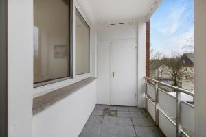 einen Balkon mit einer Tür und einem Fenster in der Unterkunft Schickes Apartment mit Balkon in Dorsten