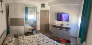 1 dormitorio con 2 camas y TV en la pared en Apartman "Park", en Livno