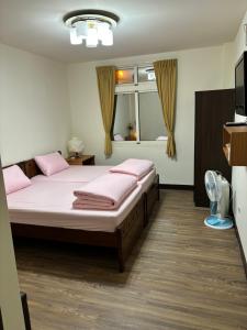 1 Schlafzimmer mit 2 Betten und einem Fenster in der Unterkunft 今友緣二館民宿 in Dongyin/
