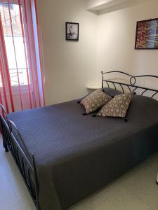 a bedroom with a black bed with pillows on it at Malocco in Pontcarré