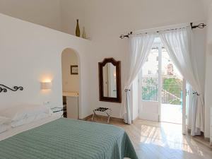 a white bedroom with a bed and a window at Regina Margherita in Positano