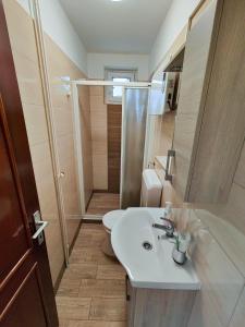 a bathroom with a white sink and a shower at Attila apartman Harkány in Harkány