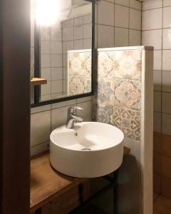 een badkamer met een witte wastafel en een spiegel bij Psamathous Guesthouse in Pórto Káyio