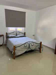 Schlafzimmer mit einem Bett und einem großen Fenster in der Unterkunft Spacious Flat in Port Louis in Port Louis
