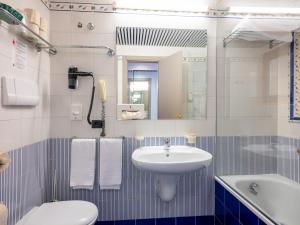 ein Badezimmer mit einem Waschbecken, einem WC und einem Spiegel in der Unterkunft Hotel San Pietro in Limone sul Garda