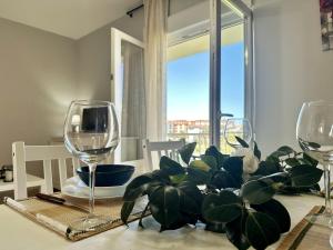 a table with two wine glasses and a potted plant at Los Girasoles - 6806 in Noja