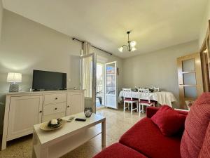 a living room with a red couch and a tv at Los Girasoles - 6806 in Noja
