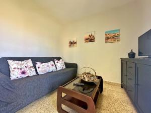 a living room with a blue couch and a coffee table at La Esteluca - 6805 in Noja