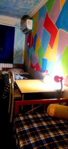Cette chambre dispose d'une table et d'un mur coloré. dans l'établissement Asine Yerevan, à Erevan