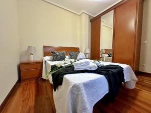 1 dormitorio con 1 cama con manta blanca y negra en La Sirenuca, en Santoña