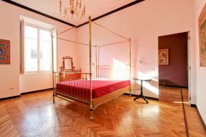 una camera con letto a baldacchino e coperta rossa di Tibullo ,Classico ed Elegante Appartamento a Roma Altre 18 foto