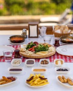 una mesa con comida y platos de comida en ella en Mesken otel, en Gokceada Town