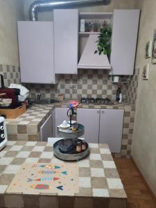 a kitchen with white cabinets and a table at Appartamento Il Vicoletto in La Spezia