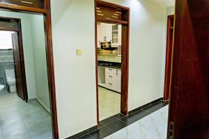 a kitchen with two large mirrors in a room at Crown Elegance Suites in Kampala +66 photos