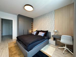 a bedroom with a bed and a desk and a chair at Nivy, parkovanie, blizko centra in Nivy