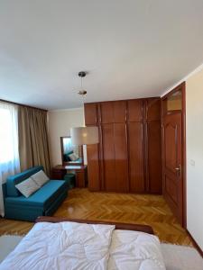 1 dormitorio con 1 cama, 1 silla y 1 armario en Apartmani Central 12 & Free parking, en Vrnjačka Banja