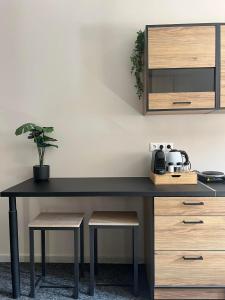 Un escritorio negro con una maceta. en Boutique Studios & Apartments - by Avelink, en Spáta
