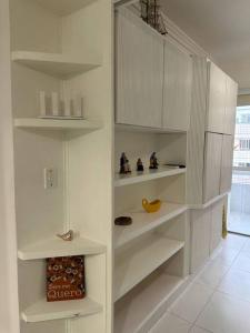 a kitchen with white shelves in a room at Ape Caiobá vznho boliche e Assoc Caixa Econômica in Matinhos