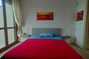 Bilo De Andrè في ريميني: غرفة نوم بسرير احمر مع بطانية حمراء
