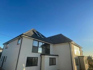 a white house with a black roof at Excalibur 3 Bed sleeps 7 in Tintagel