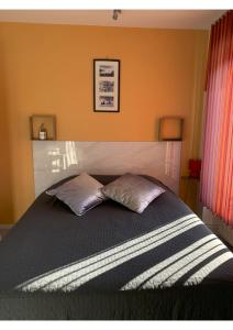 a bedroom with a bed with two pillows on it at Malocco in Pontcarré