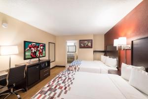a hotel room with two beds and a flat screen tv at Red Roof Inn Temple in Temple