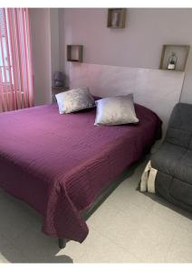 a bedroom with a purple bed and a chair at chez stephane in Pontcarré +8 photos