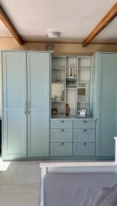 a kitchen with blue cabinets and a stove at Blue Bay Studio Bayview in Cape Town +17 photos