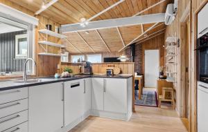 a kitchen with white cabinets and a wooden ceiling at Stunning Home In Sjølund With Kitchen in Sjølund