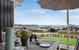 a table with an umbrella and a view of a yard at Stunning Home In Sjlund With Kitchen in Sjølund