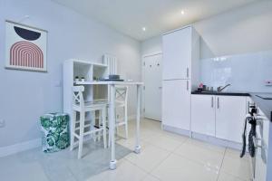 uma cozinha branca com armários brancos e um balcão em StayRight 1-Bed City Nest in Cardiff em Cardiff