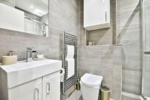 uma casa de banho com um WC, um lavatório e um espelho. em StayRight 1-Bed City Nest in Cardiff em Cardiff
